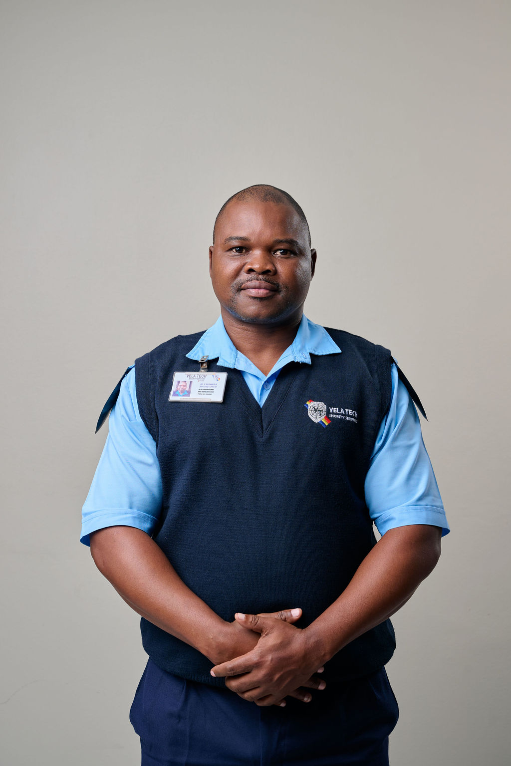 A uniformed Vela-Tech Security officer with ID badge on duty